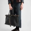 Bolso de cuero con hebilla de Prada y cinturón con tachuelas