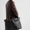 Bolso de cuero con hebilla de Prada y cinturón con tachuelas