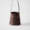 Bolso tipo cubo de cuero con hebilla de Prada y cinturón con joyas Bolso tipo cubo de cuero con hebilla de Prada y cinturón con joyas