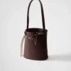 Bolso tipo cubo de cuero con hebilla de Prada y cinturón con joyas Bolso tipo cubo de cuero con hebilla de Prada y cinturón con joyas
