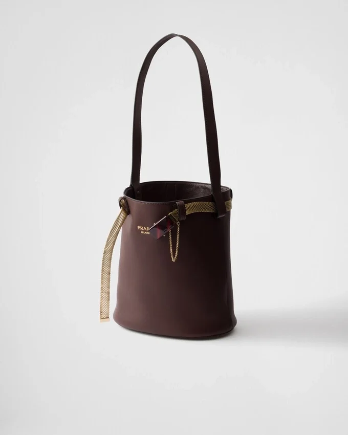 Bolso tipo cubo de cuero con hebilla de Prada y cinturón con joyas Bolso tipo cubo de cuero con hebilla de Prada y cinturón con joyas