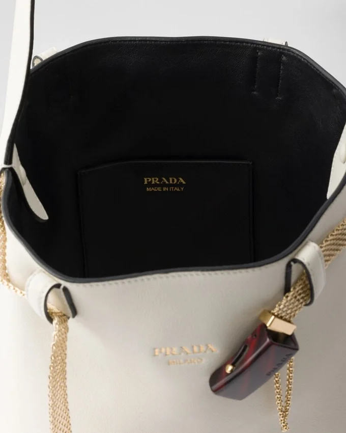 Bolso tipo cubo de cuero con hebilla de Prada y cinturón con joyas Bolso tipo cubo de cuero con hebilla de Prada y cinturón con joyas