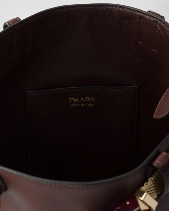 Bolso tipo cubo de cuero con hebilla de Prada y cinturón con joyas Bolso tipo cubo de cuero con hebilla de Prada y cinturón con joyas