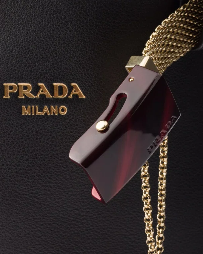 Bolso tipo cubo de cuero con hebilla de Prada y cinturón con joyas Bolso tipo cubo de cuero con hebilla de Prada y cinturón con joyas