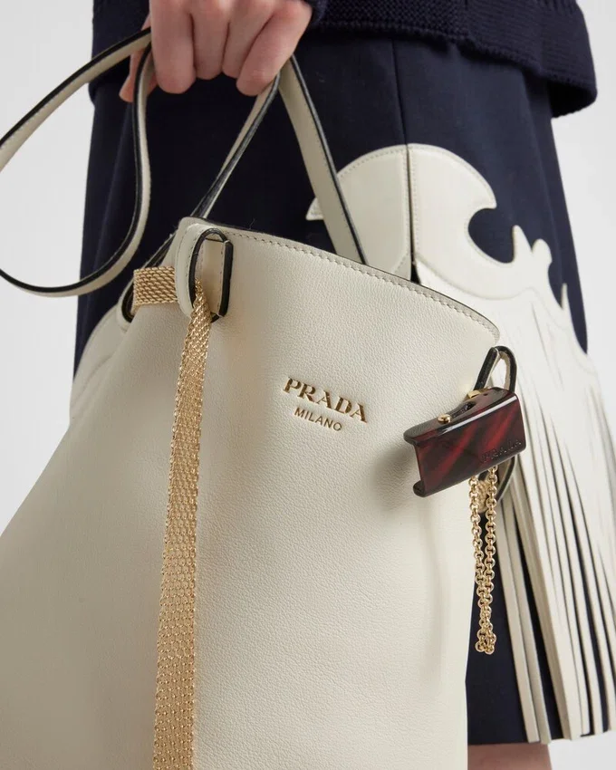 Bolso tipo cubo de cuero con hebilla de Prada y cinturón con joyas Bolso tipo cubo de cuero con hebilla de Prada y cinturón con joyas