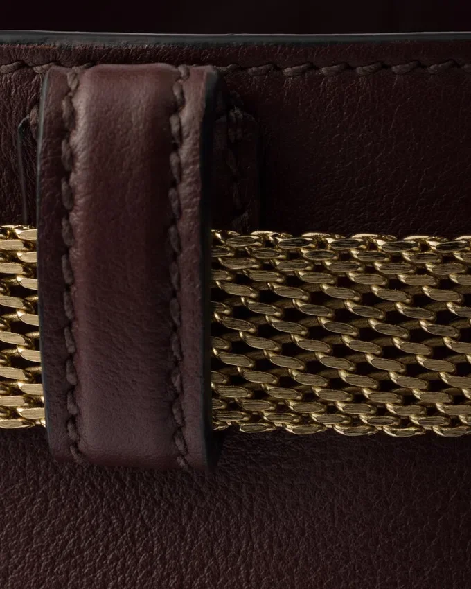 Bolso tipo cubo de cuero con hebilla de Prada y cinturón con joyas Bolso tipo cubo de cuero con hebilla de Prada y cinturón con joyas