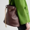 Bolso tipo cubo de cuero con hebilla de Prada y cinturón con joyas Bolso tipo cubo de cuero con hebilla de Prada y cinturón con joyas