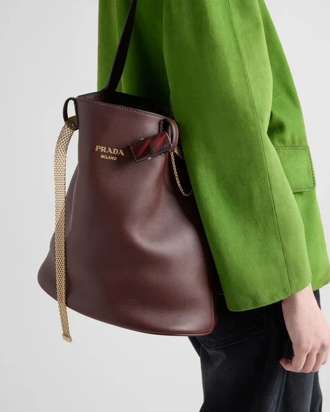 Bolso tipo cubo de cuero con hebilla de Prada y cinturón con joyas Bolso tipo cubo de cuero con hebilla de Prada y cinturón con joyas