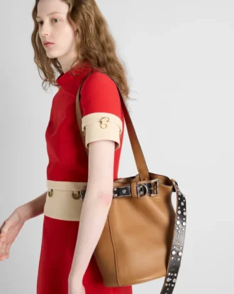 Bolso tipo cubo de cuero con hebilla Prada y cinturón con tachuelas