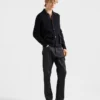 Pantalones de mezclilla sin tratar con tira de cuero Pantalones de mezclilla sin tratar con tira de cuero